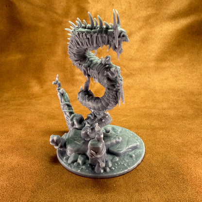 Fantasy figurine of a dragon-like creature on a round base against an orange background