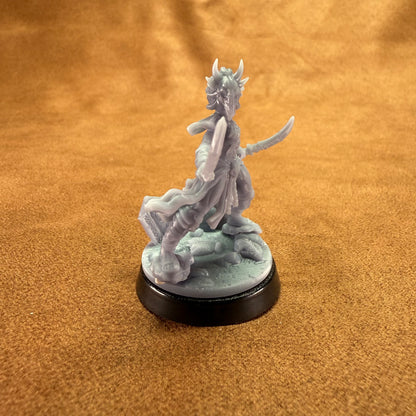 Gray fantasy figurine on a black base against an orange fabric background