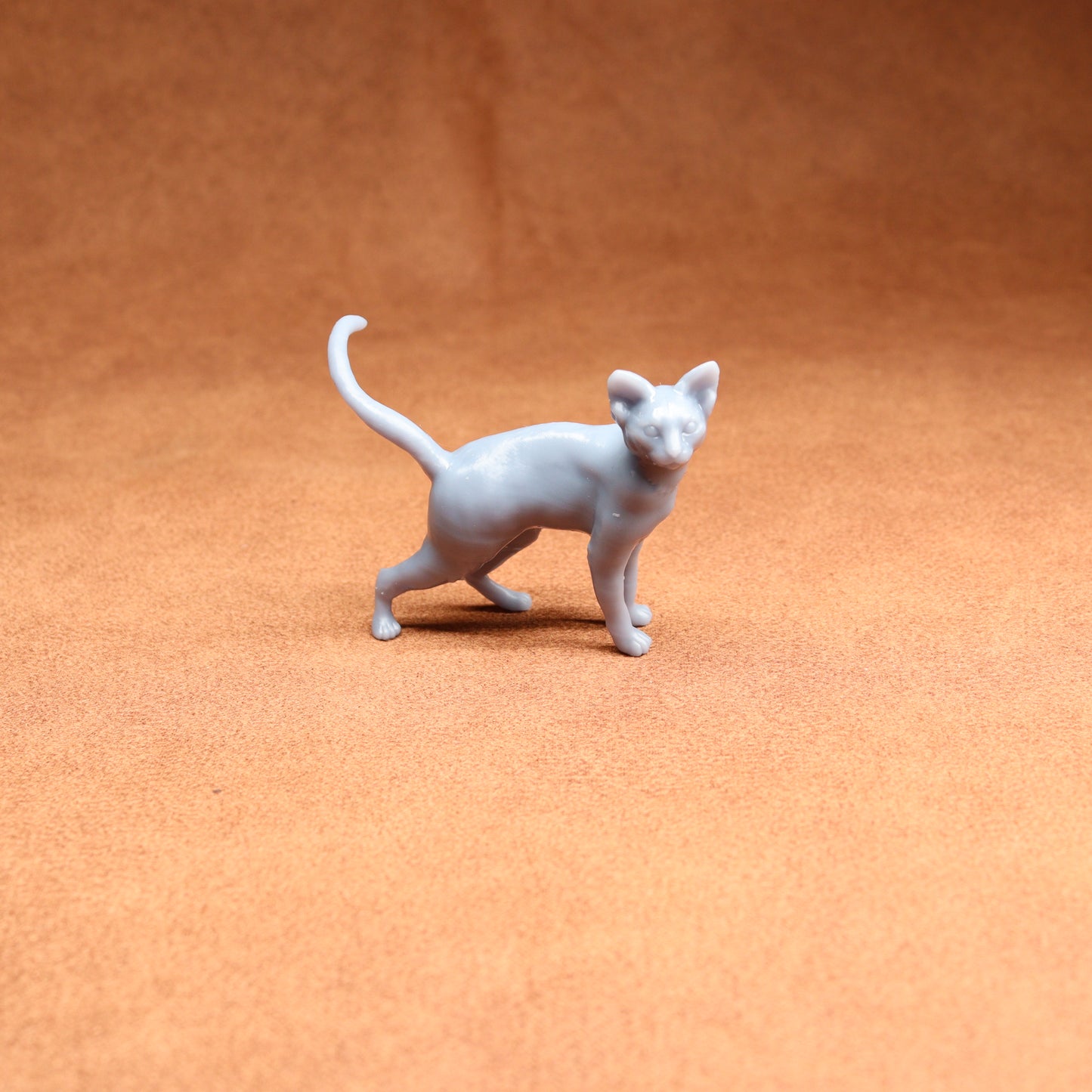 White cat figurine on a brown surface