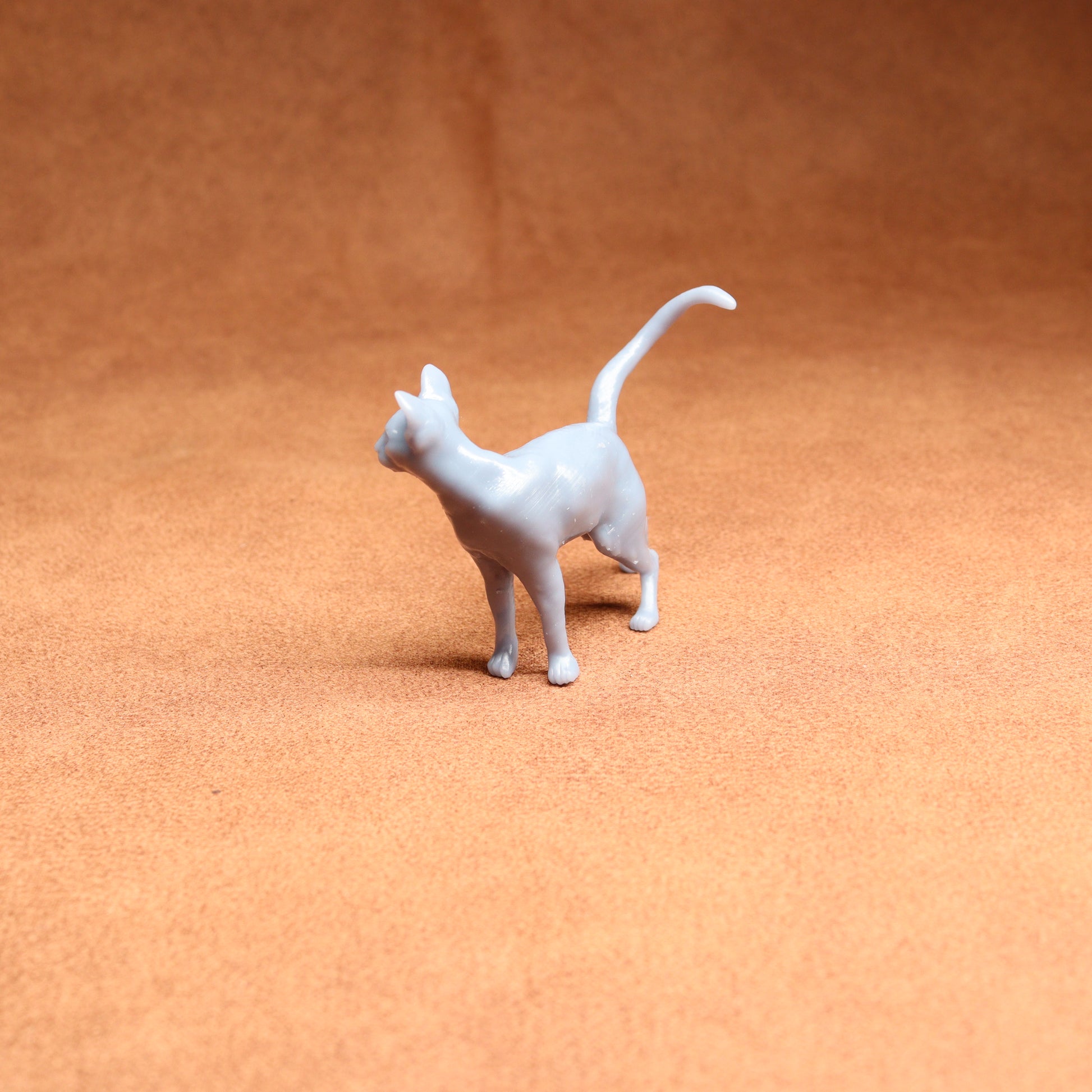 White cat figurine on a brown surface