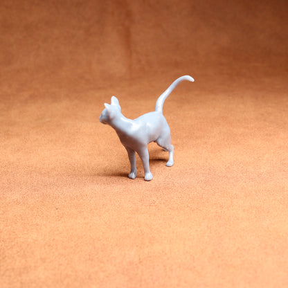 White cat figurine on a brown surface