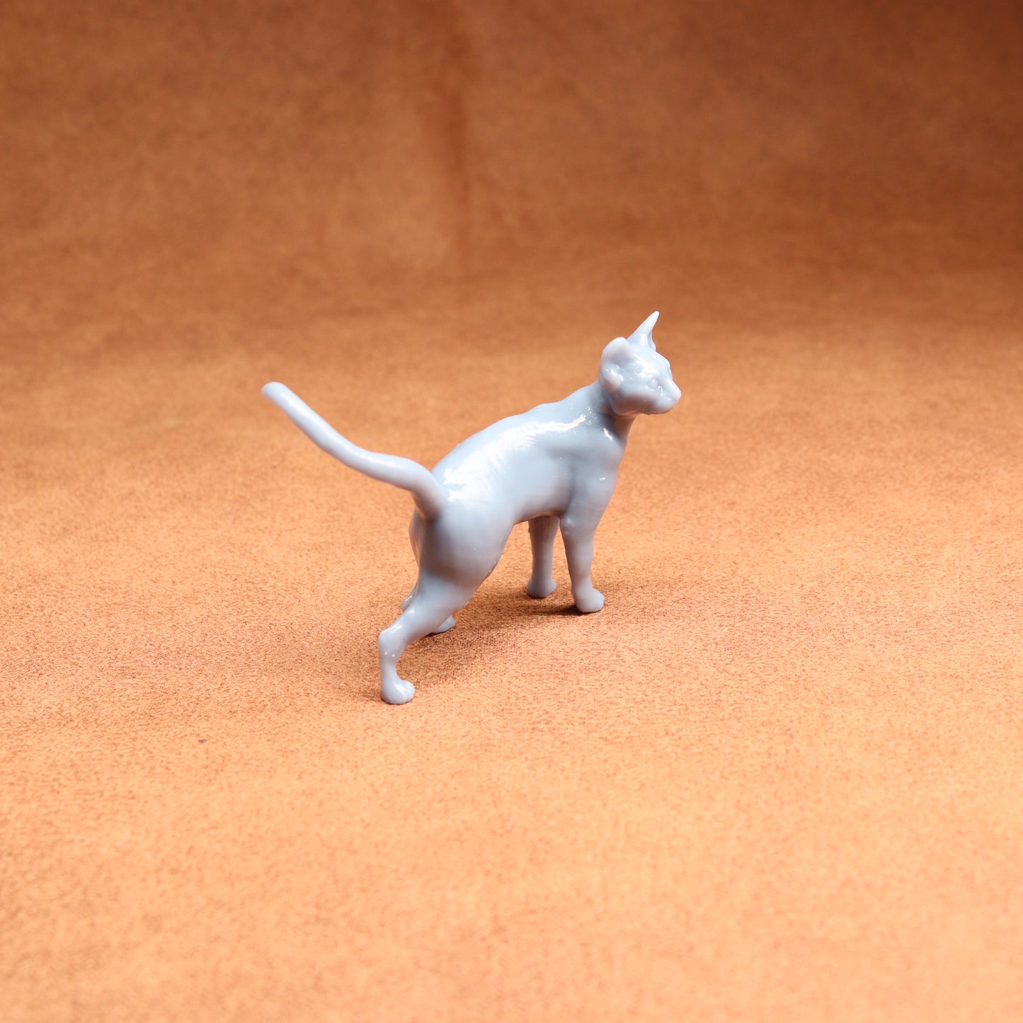 White ceramic cat figurine on a brown surface