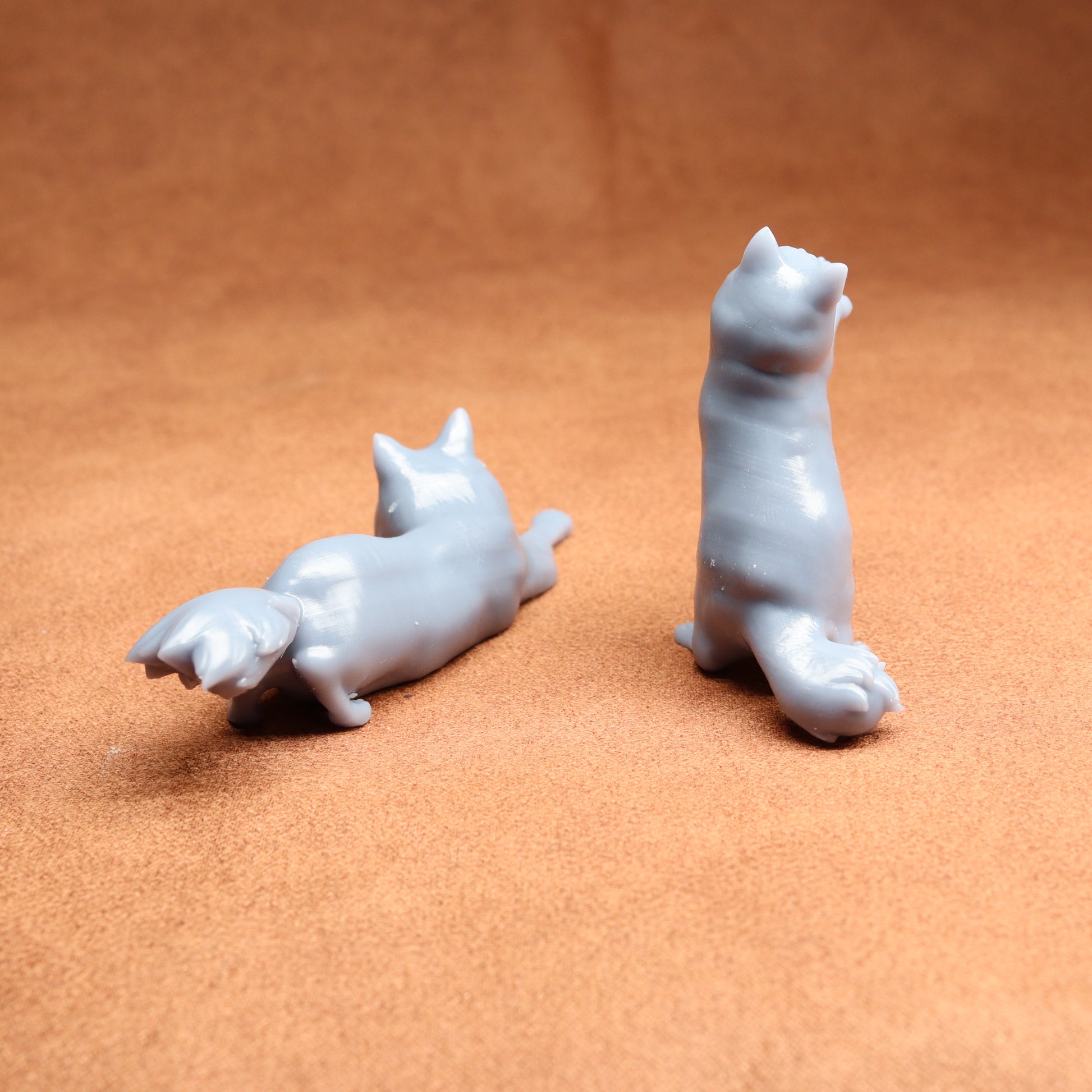 Two white ceramic dog figurines on a brown surface