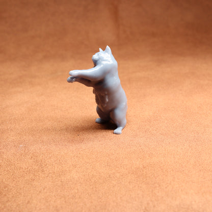 Small gray figurine of a dog on a brown surface