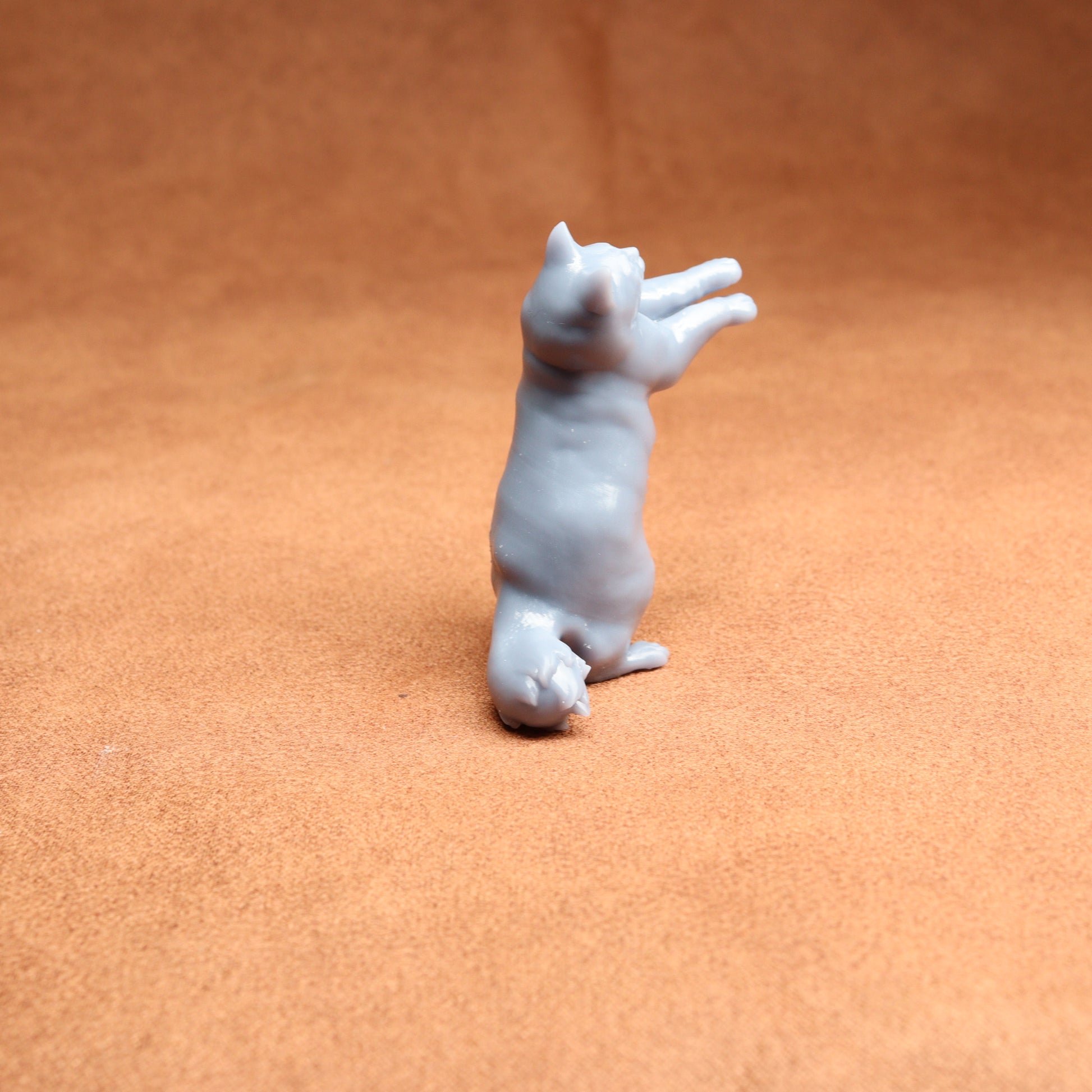 White ceramic cat figurine on a brown surface