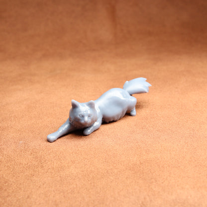 White cat figurine on a brown surface