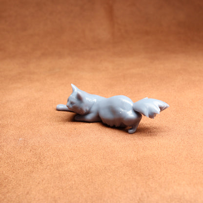 Gray cat figurine on a brown surface