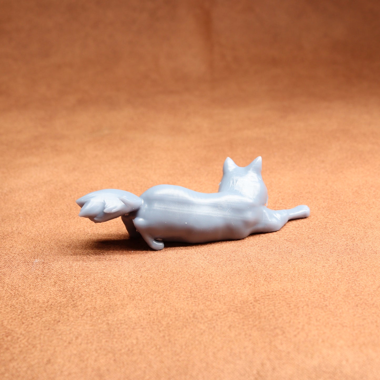White ceramic cat figurine on a brown surface