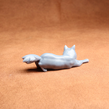 White ceramic cat figurine on a brown surface