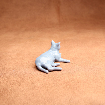 White cat figurine on a brown surface