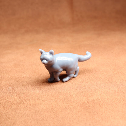 Small white cat figurine on a brown surface