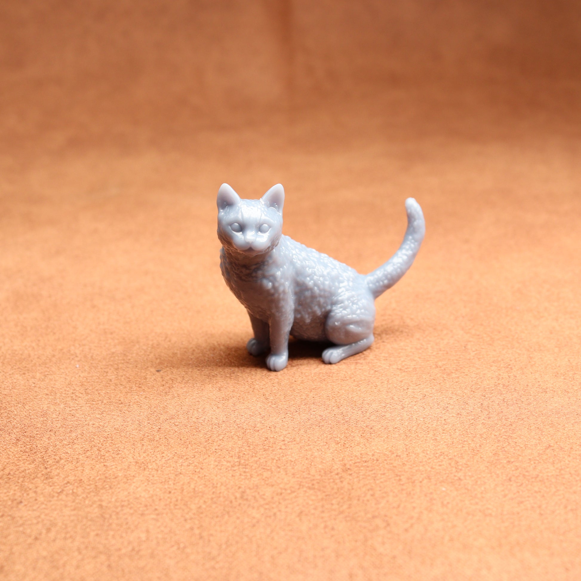 Small white cat figurine on a brown surface