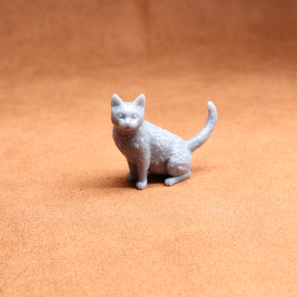 Small white cat figurine on a brown surface