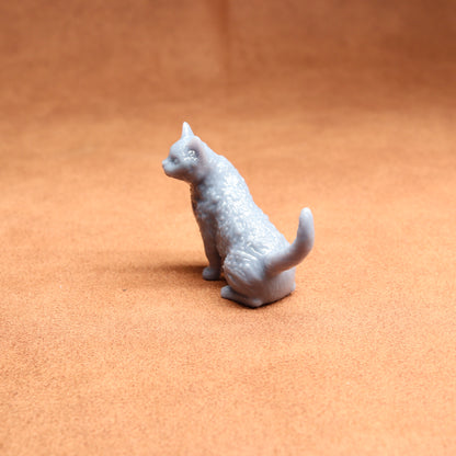 Small white cat figurine on a brown surface