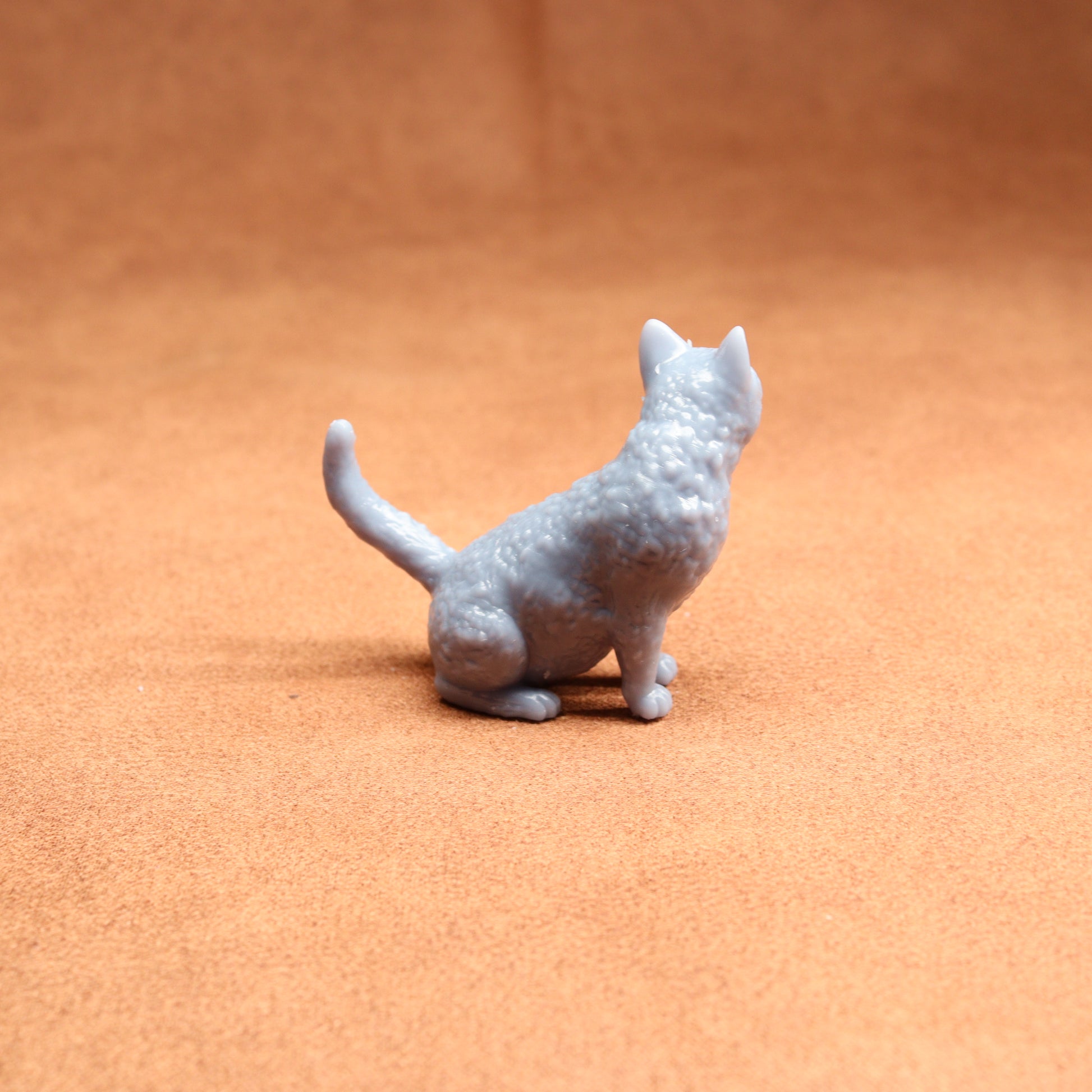 Gray cat figurine on a brown surface