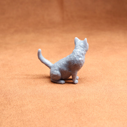 Gray cat figurine on a brown surface