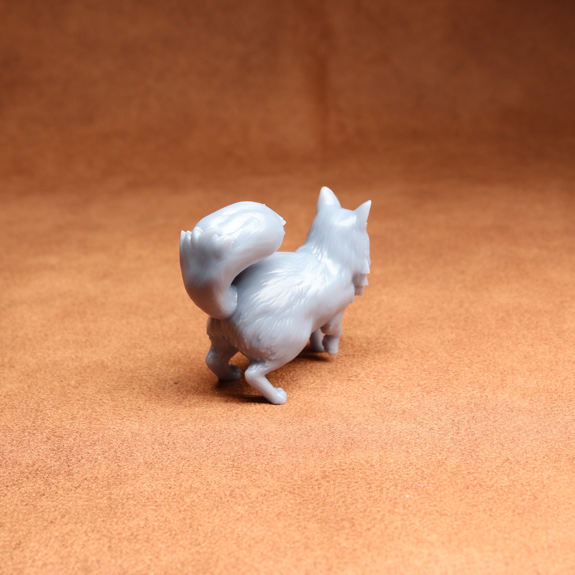 White cat figurine on a brown surface