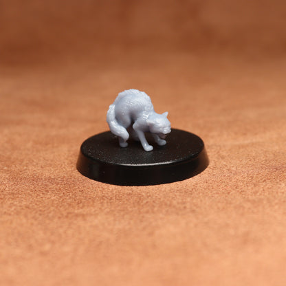 Small white figurine on a black base against a brown background