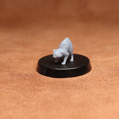 White figurine of a cat on a black base against a brown background