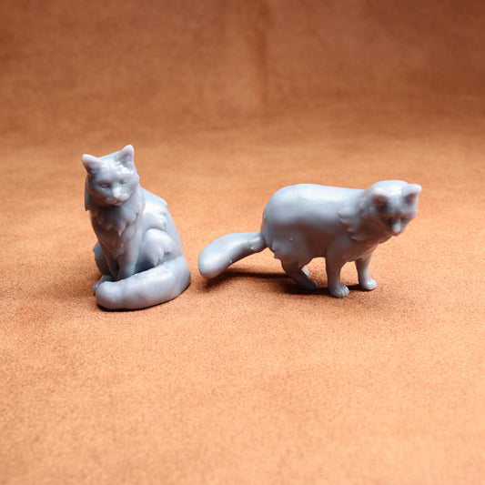 Two gray cat figurines on a brown surface