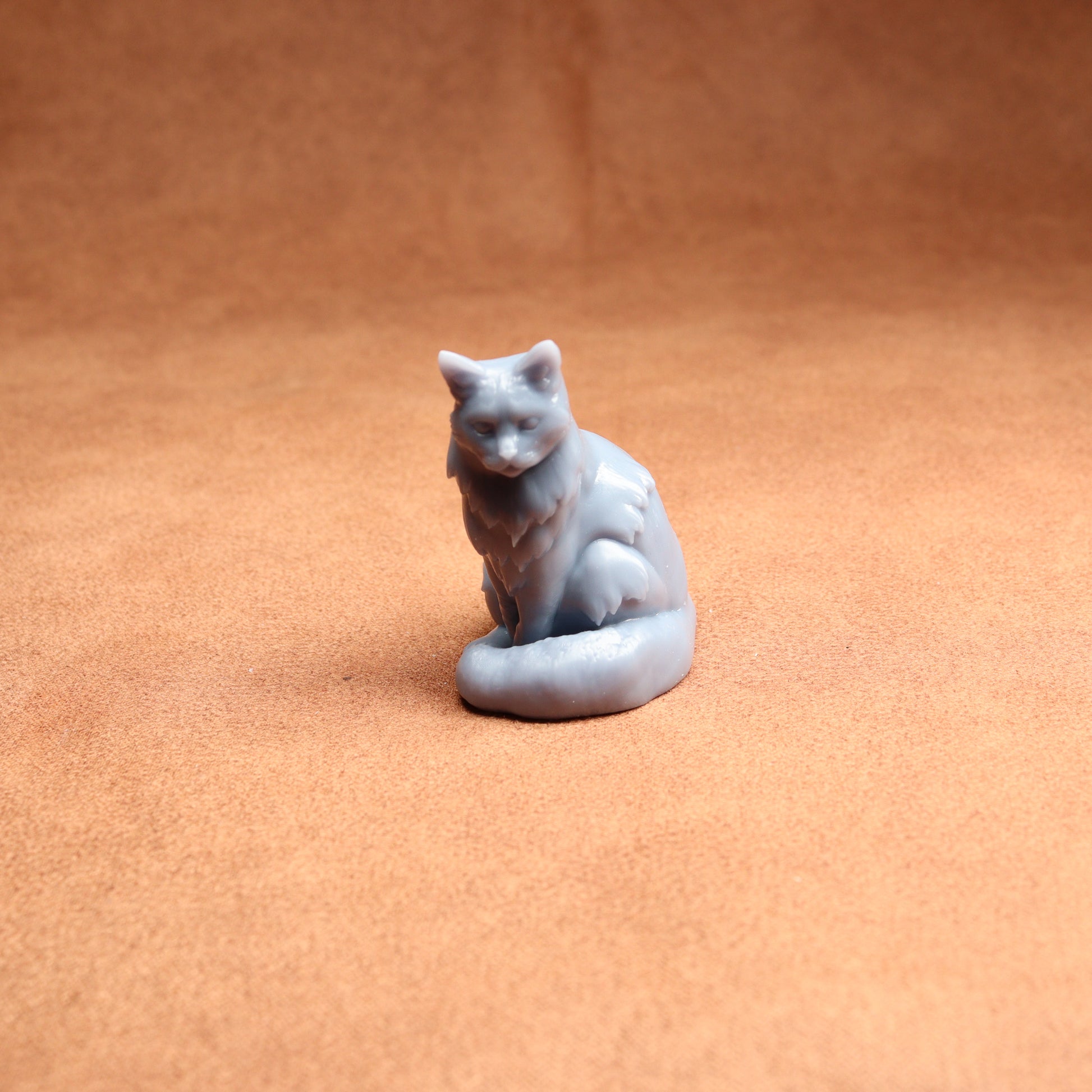 Small gray cat figurine on a brown surface