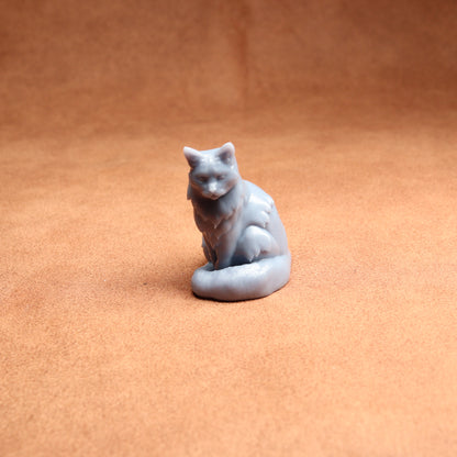 Small gray cat figurine on a brown surface