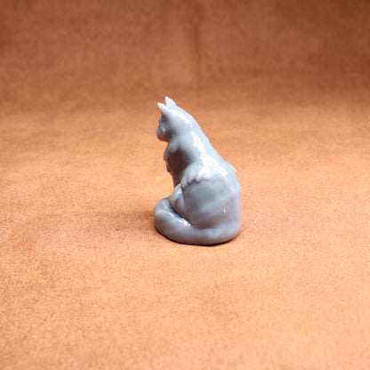Gray cat-shaped candle on a brown surface