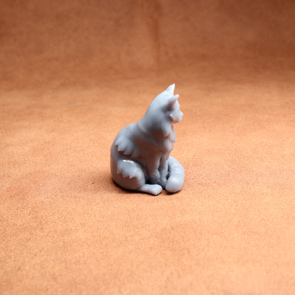 White ceramic cat figurine on a brown surface