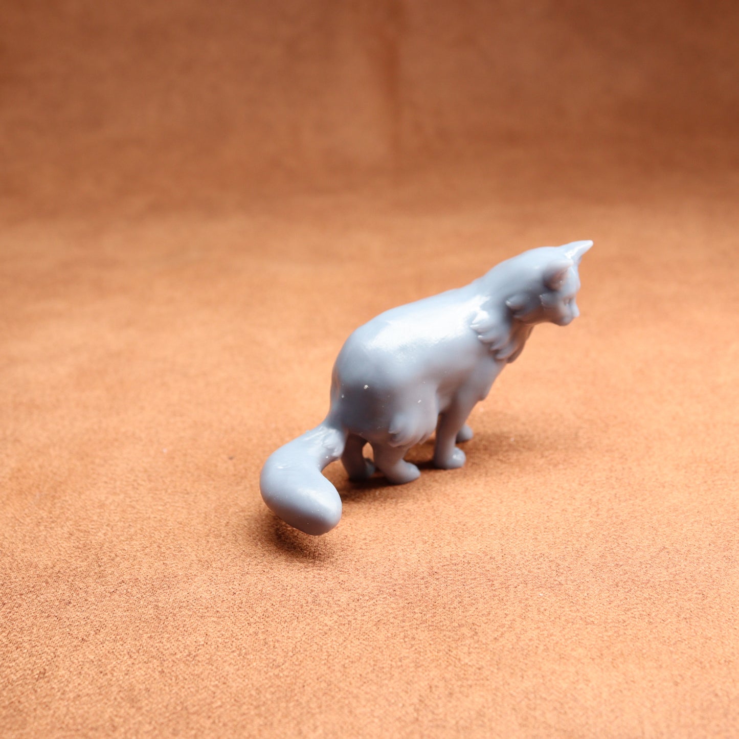 White ceramic cat figurine on a brown surface