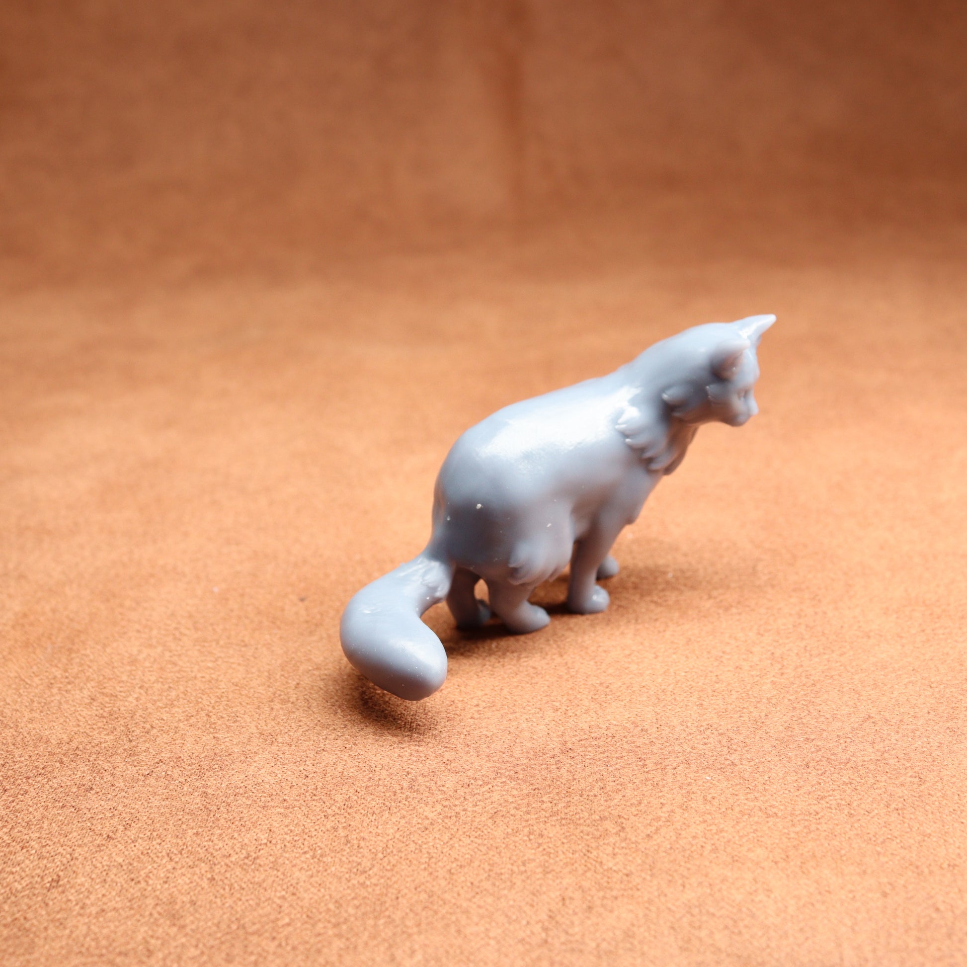 White ceramic cat figurine on a brown surface