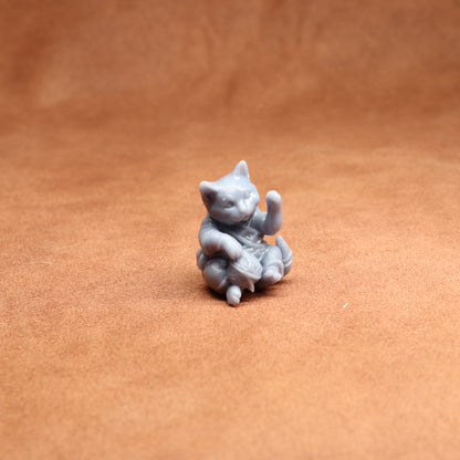 Small gray cat figurine on a brown surface