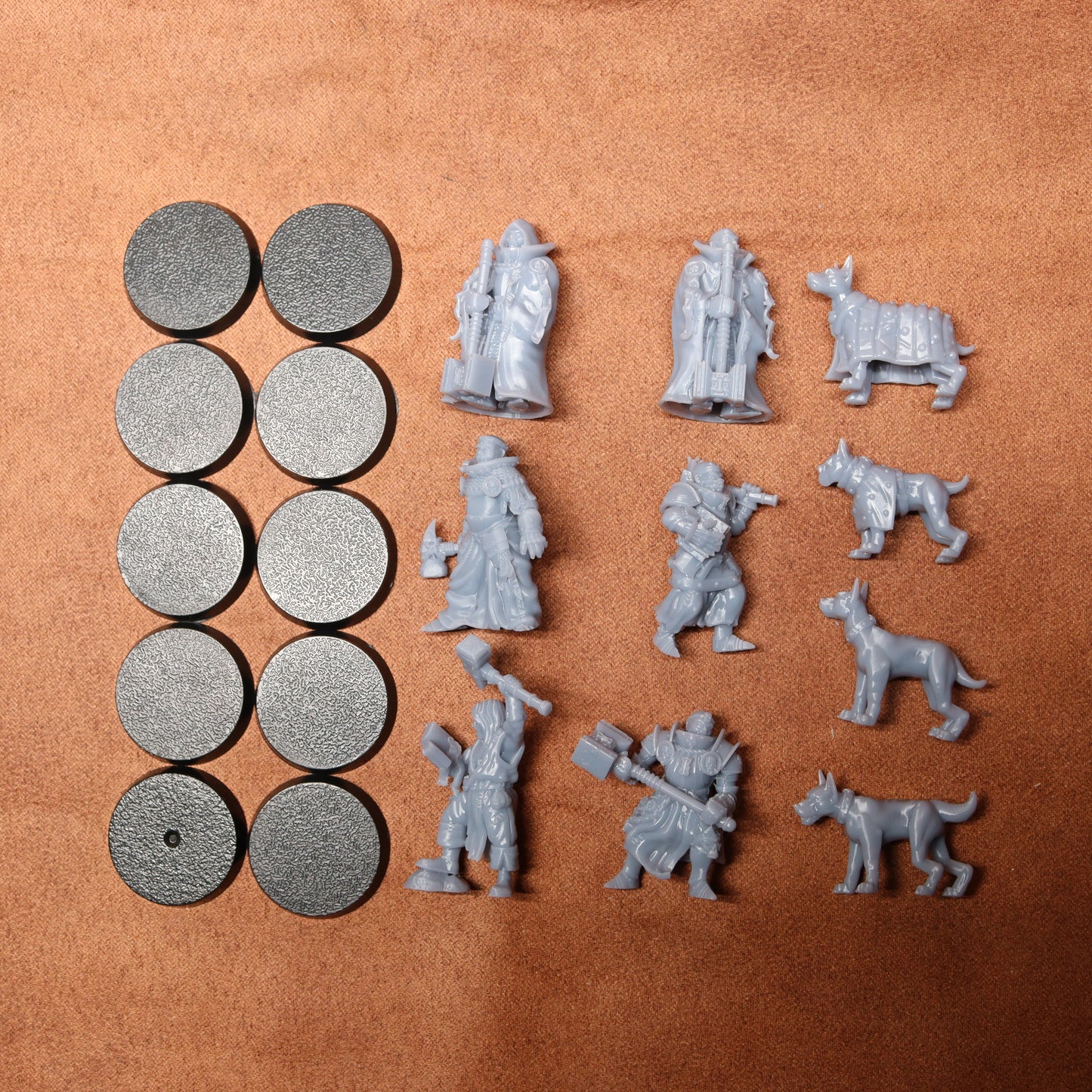 Collection of gray miniature figures and round components on a brown surface