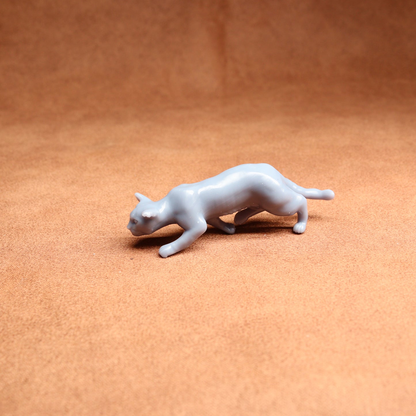 White cat figurine on a brown surface