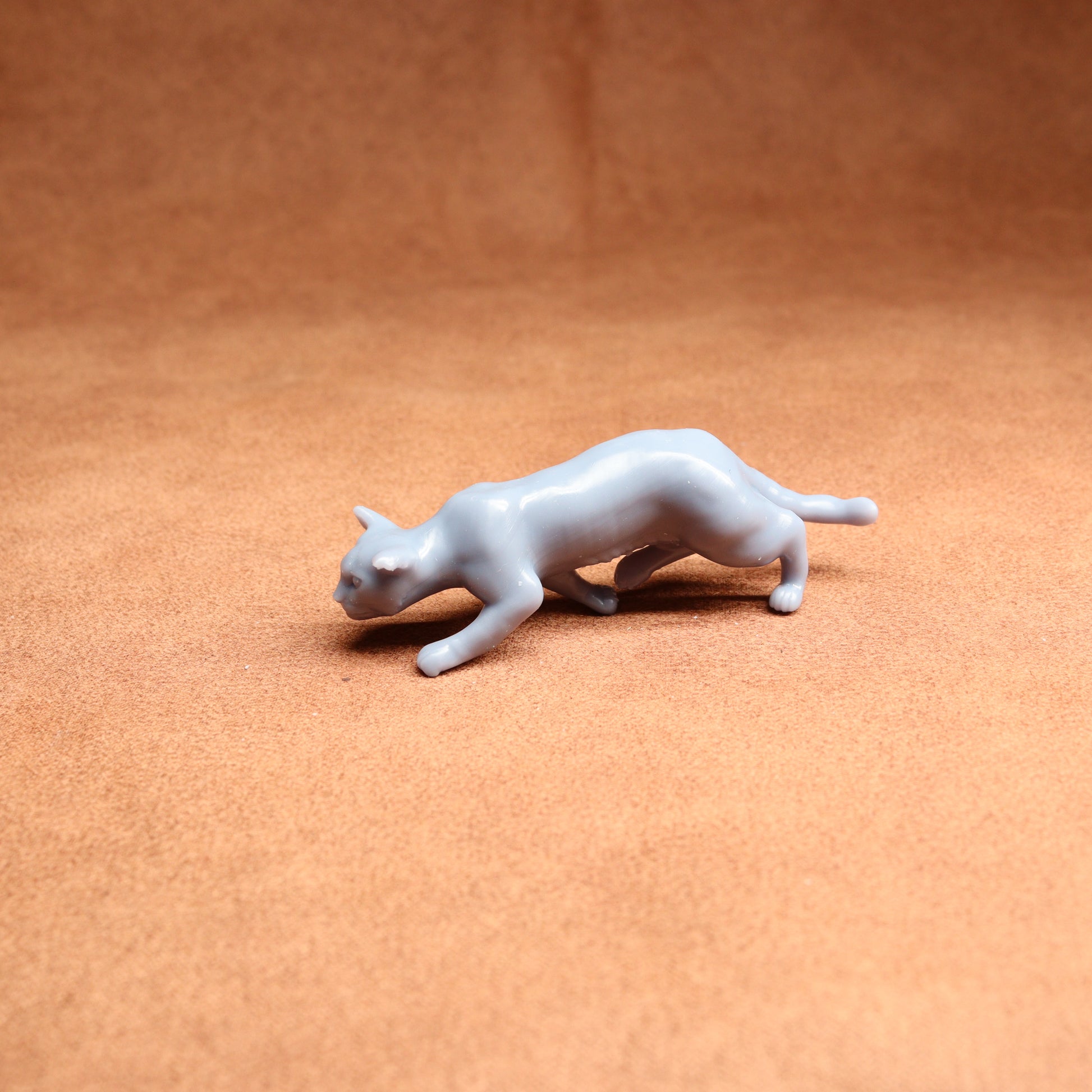 White cat figurine on a brown surface