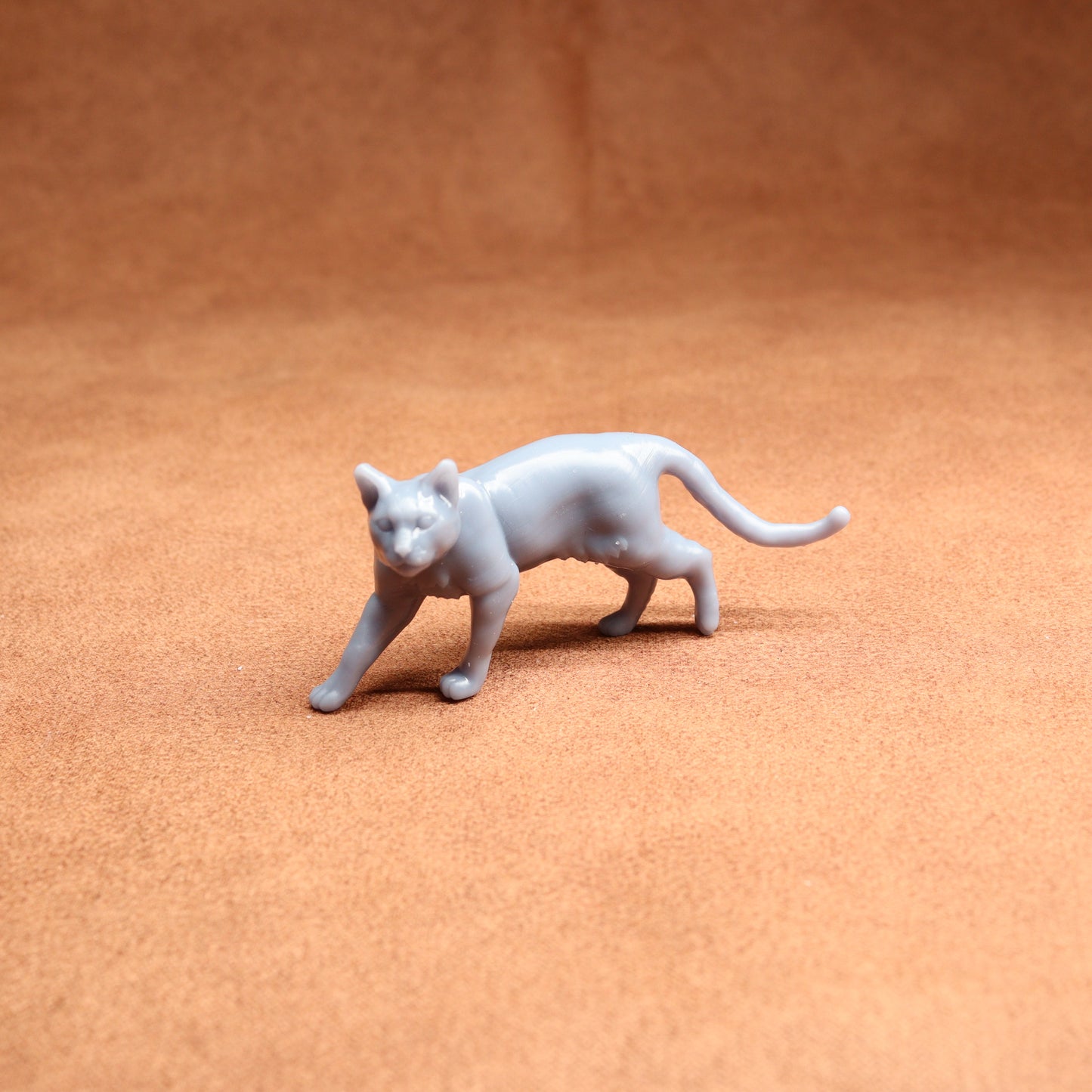 White cat figurine on a brown surface