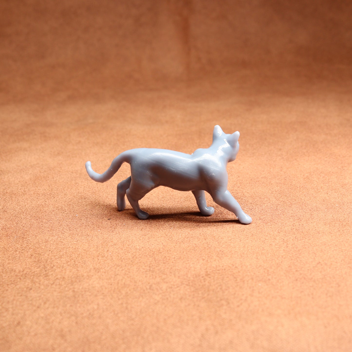 White cat figurine on a brown surface