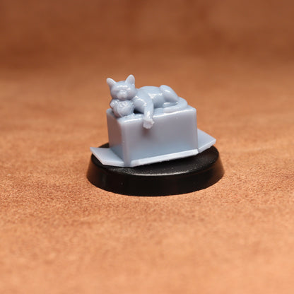 Small figurine of a cat on a box with a brown background