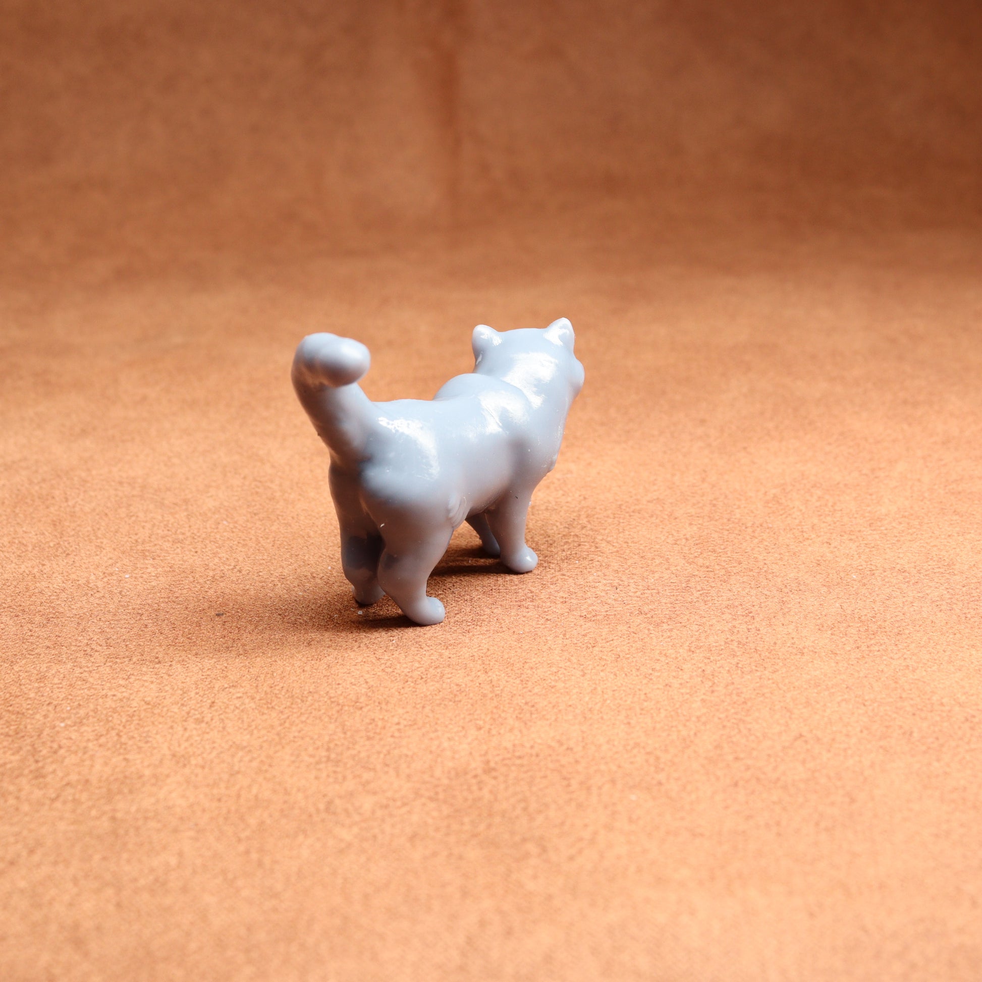 White cat figurine on a brown surface