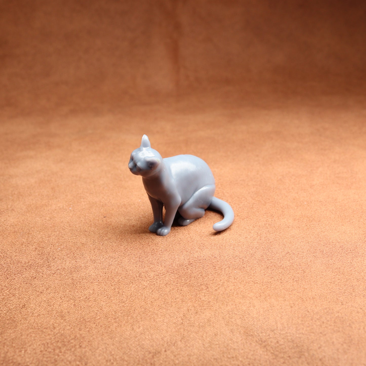 Gray cat figurine on a brown surface