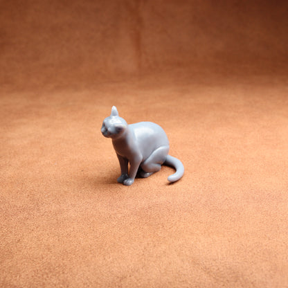 Gray cat figurine on a brown surface