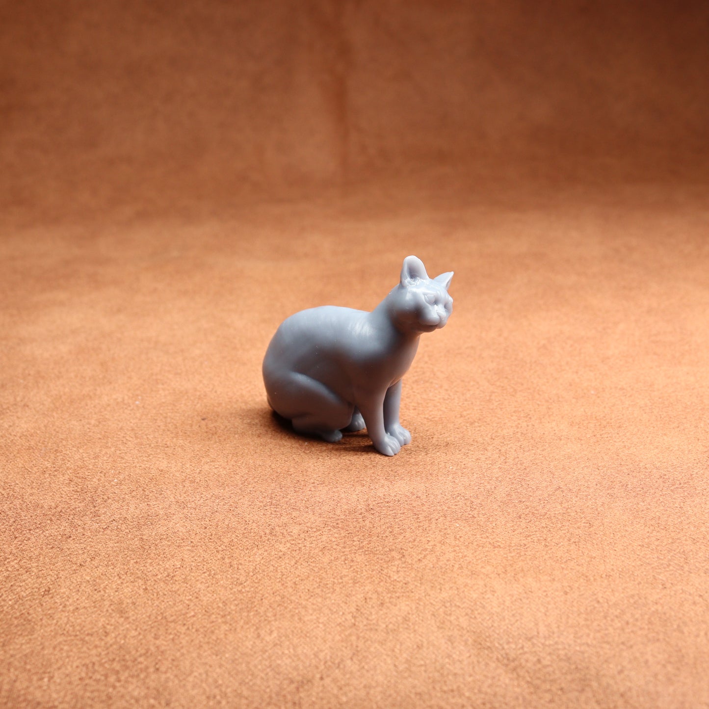 Gray cat figurine on a brown surface