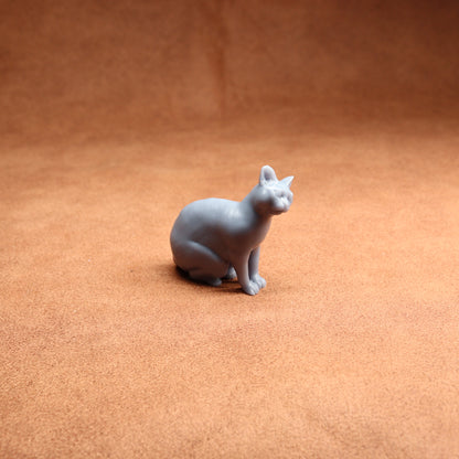 Gray cat figurine on a brown surface
