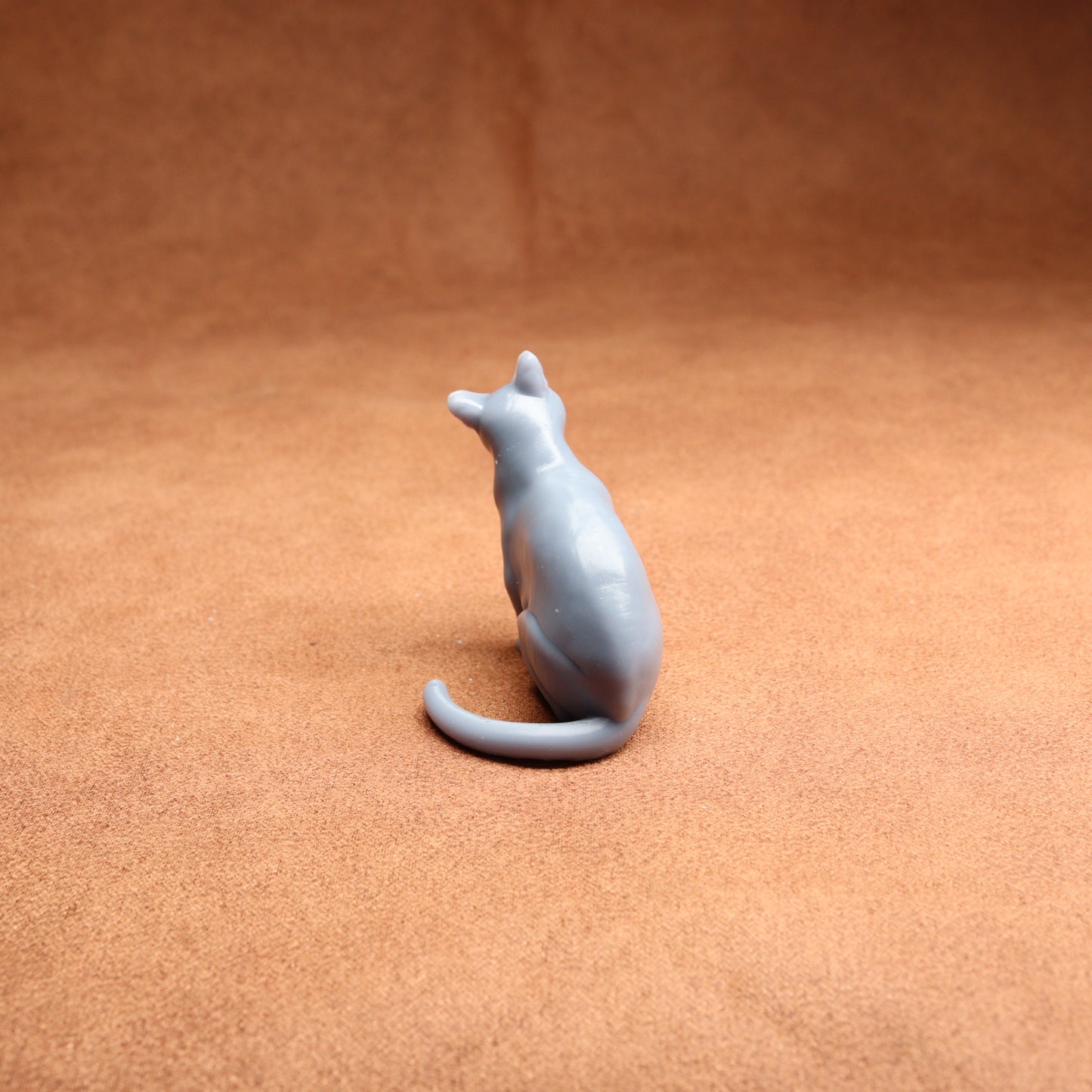 Gray cat figurine on a brown surface