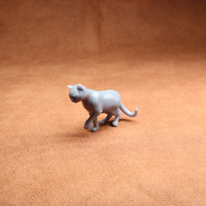 Gray toy cat figure on a brown surface