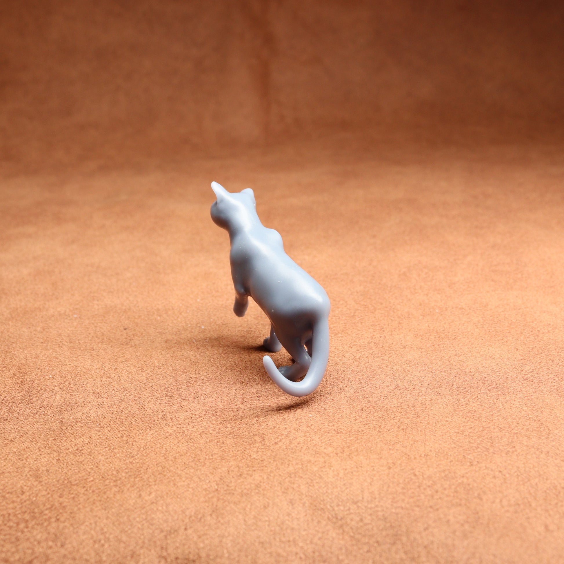 Gray cat figurine on a brown surface