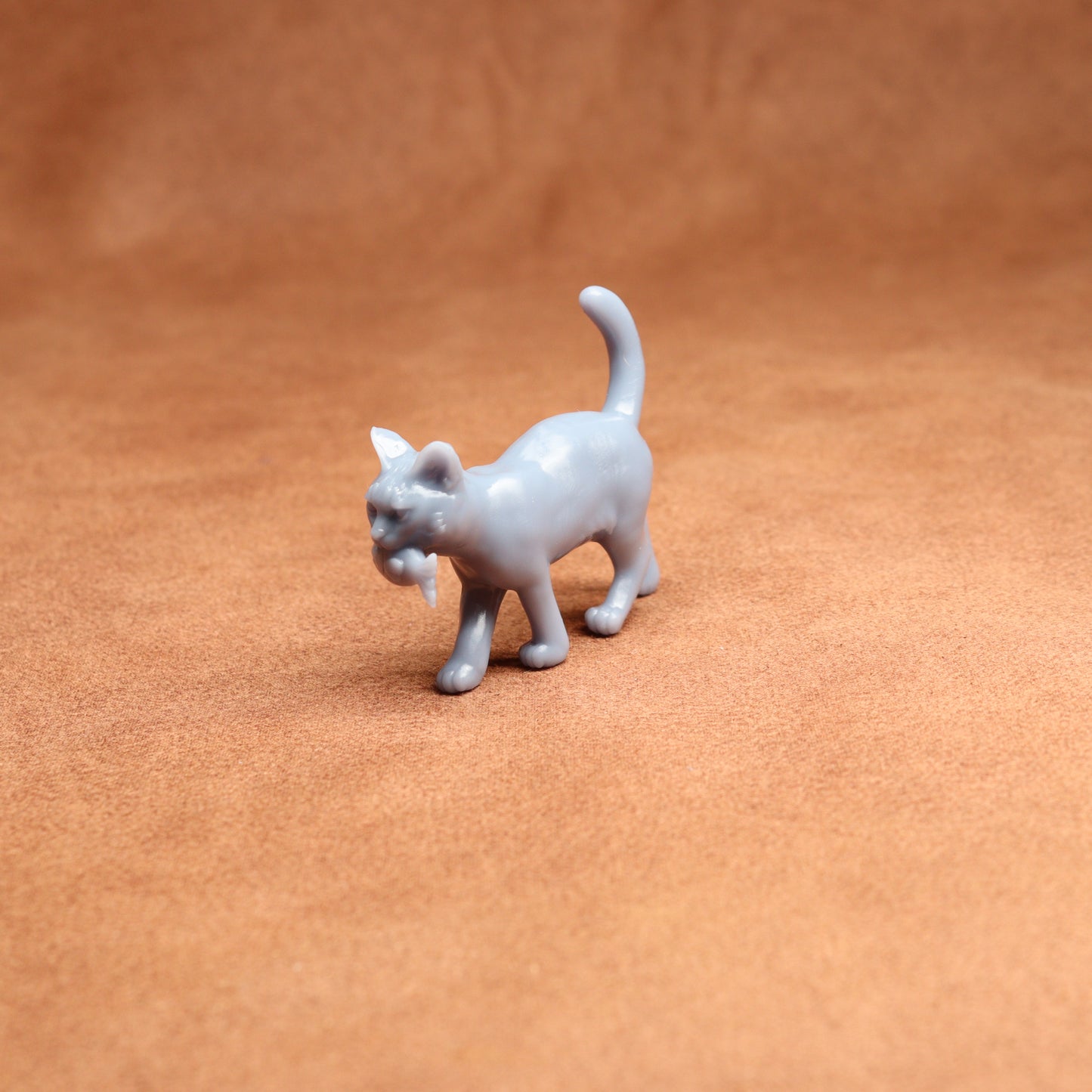 White cat figurine on a brown surface