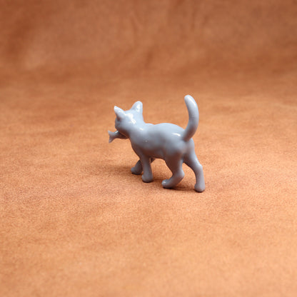 Small gray cat figurine on a brown surface