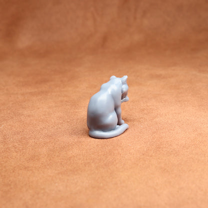 White resin cat figurine on a brown surface