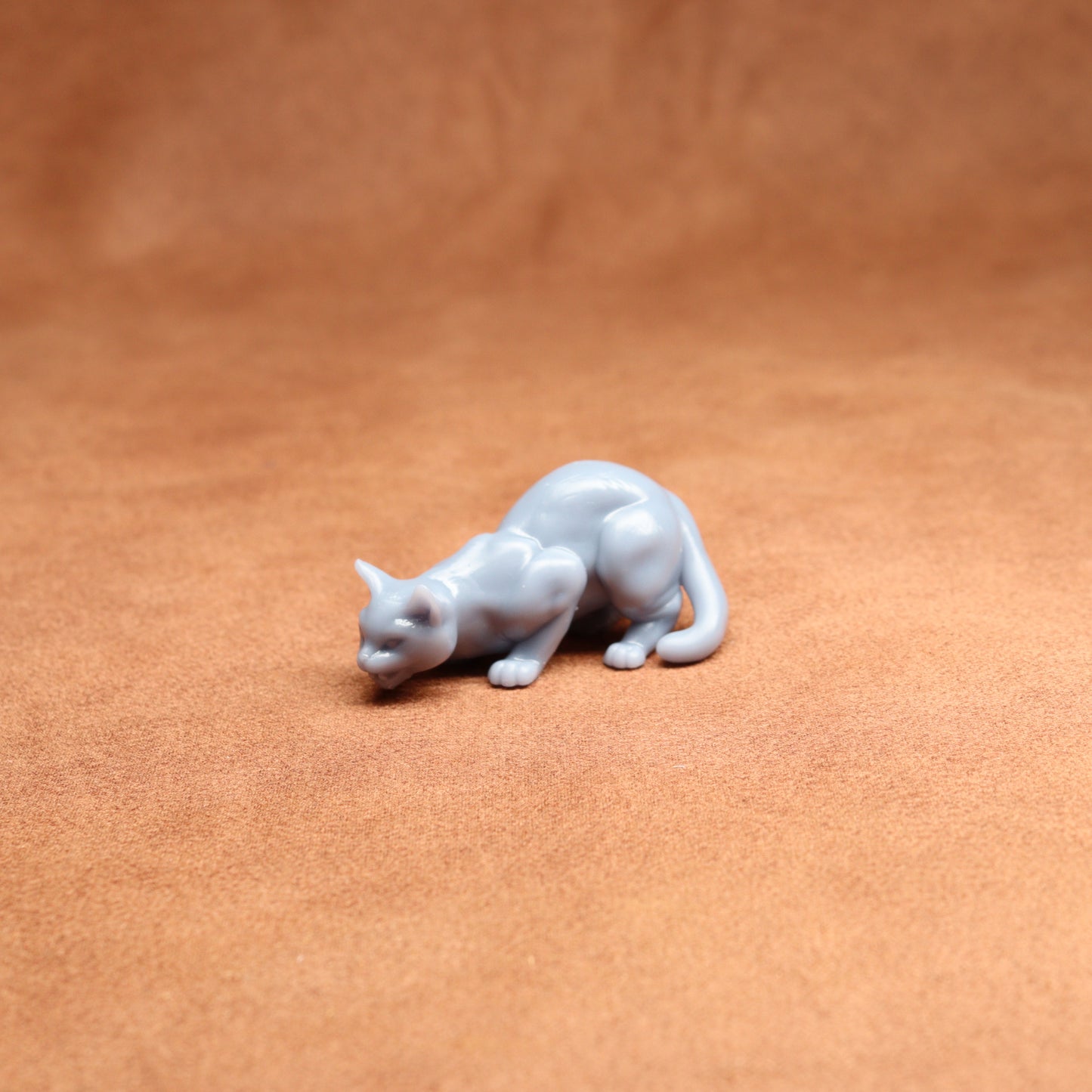 White cat figurine on a brown leather surface
