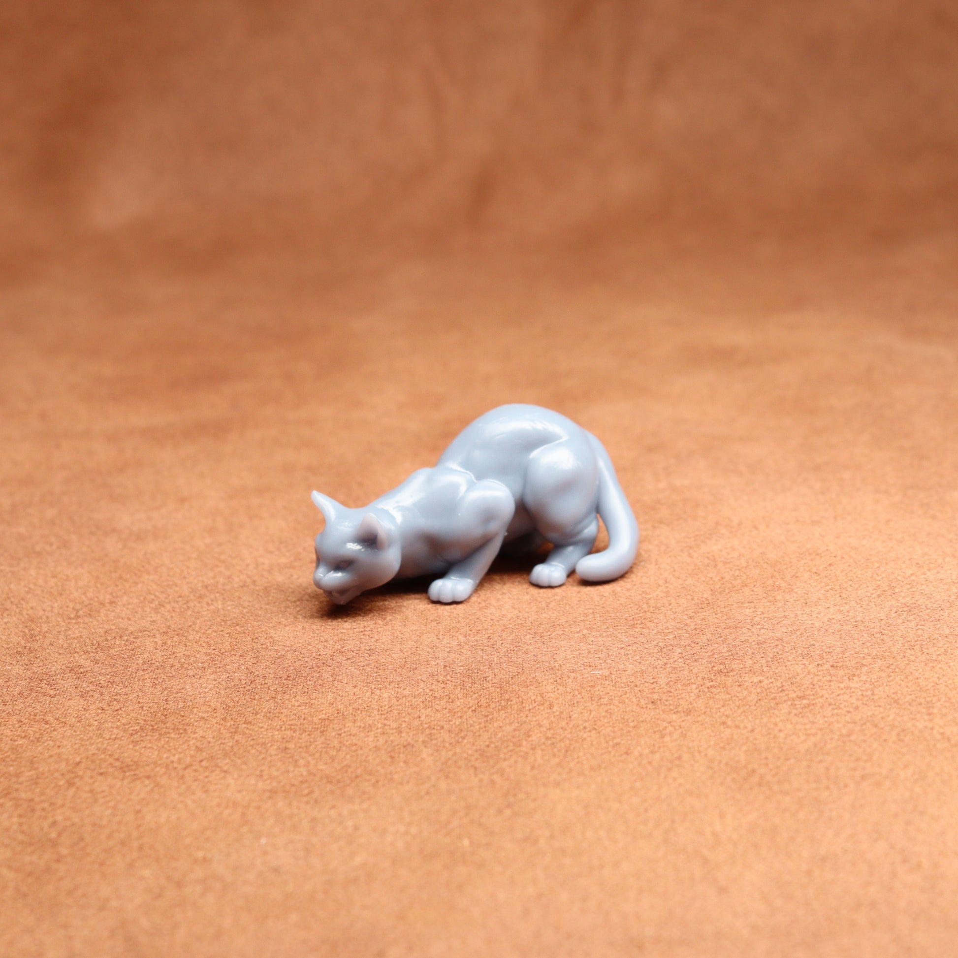 White cat figurine on a brown leather surface
